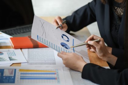 Female accountant team is analyzing data documents in the office